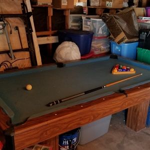 Billiard Pool table with balls and stick.